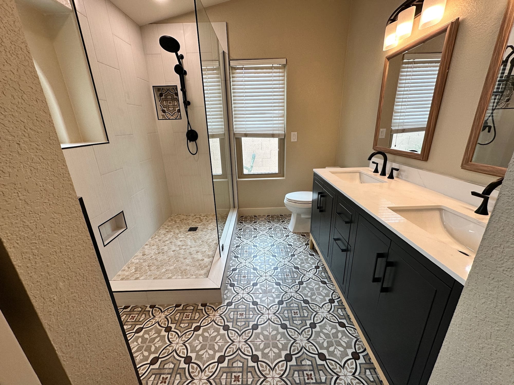 Ahwatukee master bathroom after — wide view showing the new walk-in shower and freestanding vanity tied together by the patterned tile floor