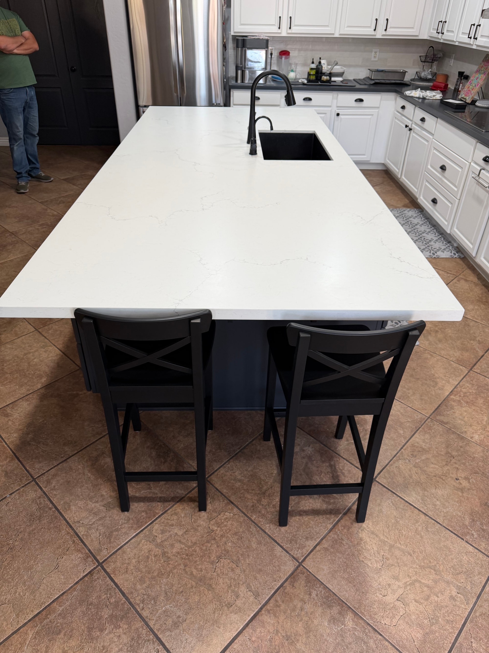 Chandler kitchen — far end of the island with bar seating for two, showing the honed quartz top overhang and the matte grey Sollid cabinetry