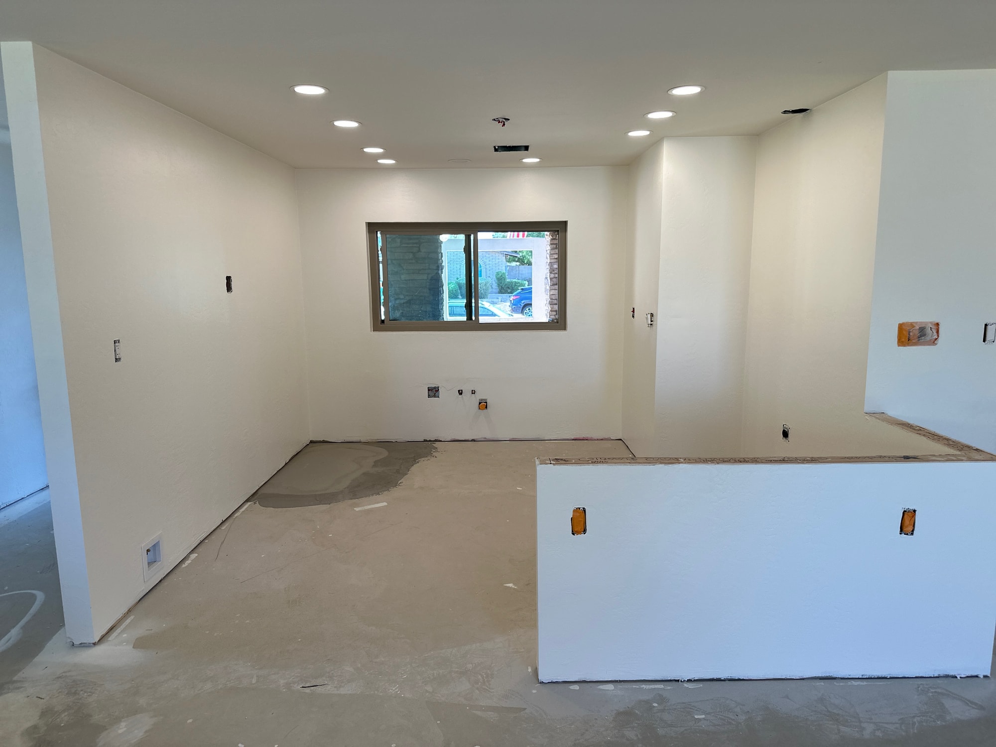 Chandler kitchen before — demoed to primed drywall after a pipe burst in the ceiling caused whole-house water damage; subfloor exposed, walls painted and ready for the rebuild