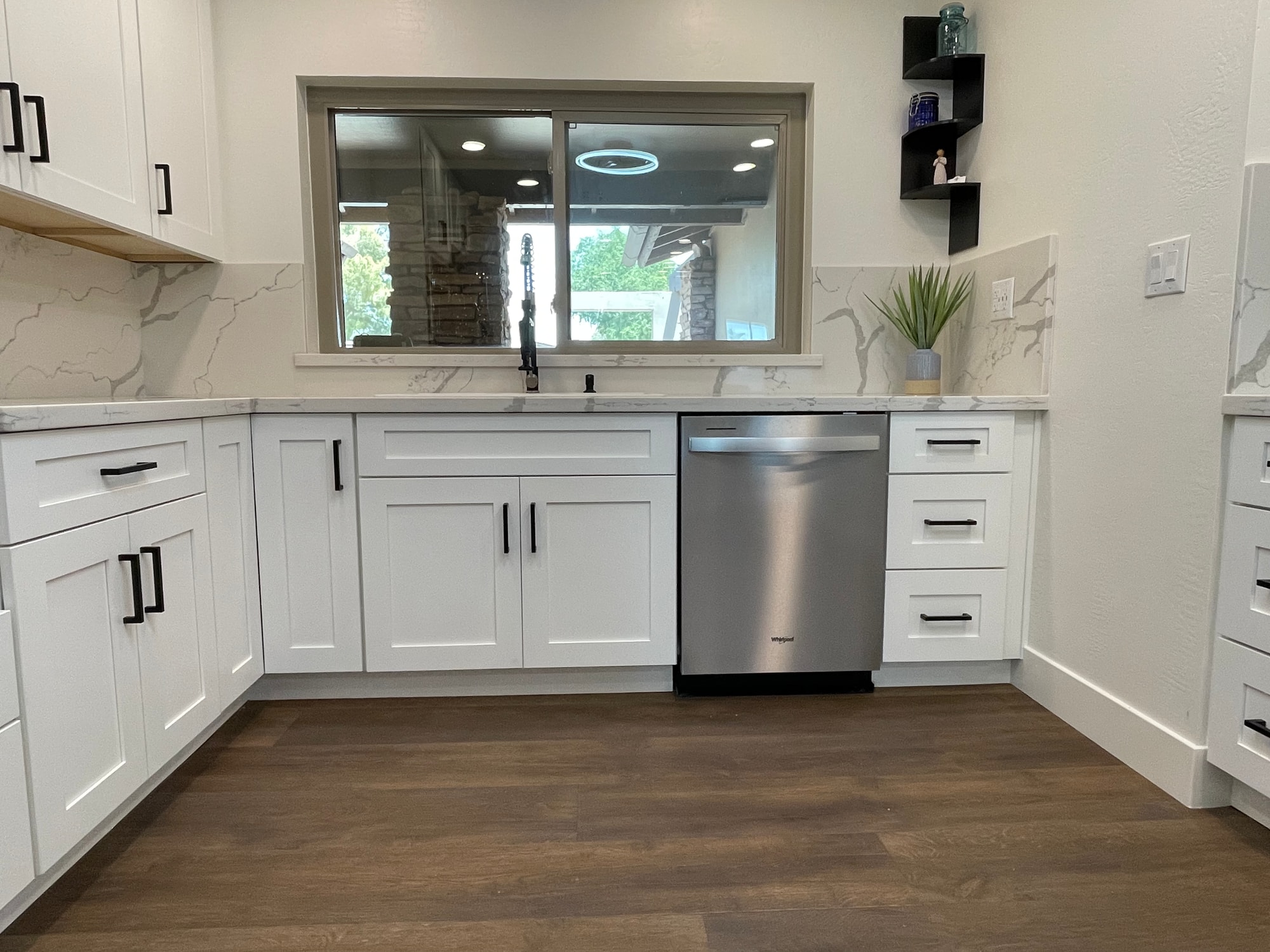 Chandler kitchen — main sink wall straight on, showing the stainless four-door refrigerator, built-in double wall oven, and continuous Calacatta Divine quartz