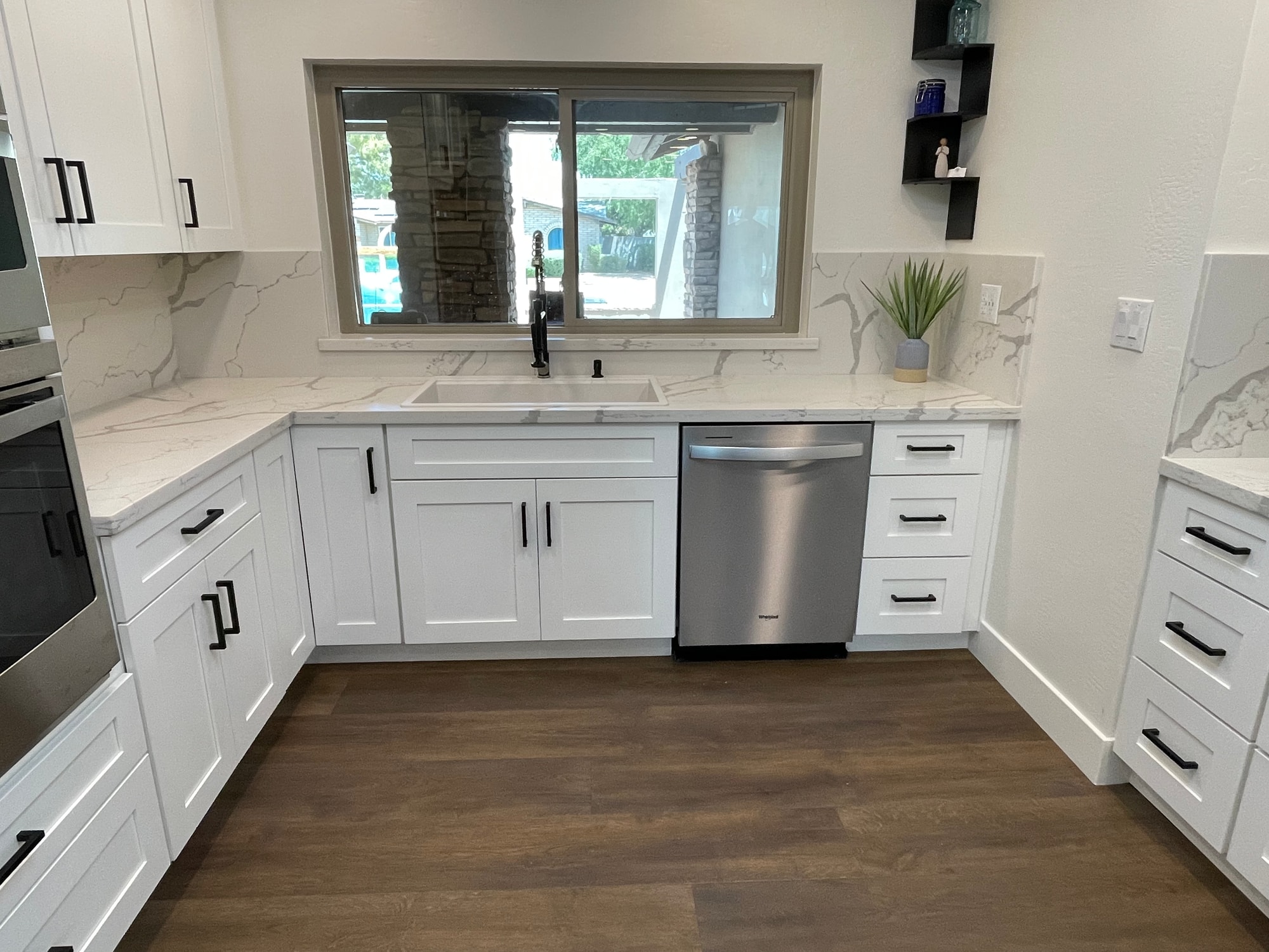 Chandler kitchen — detail of the main sink area with Sollid Shaker White cabinets, matte black pulls, pulldown faucet, and the Della Terra Calacatta Divine backsplash veining