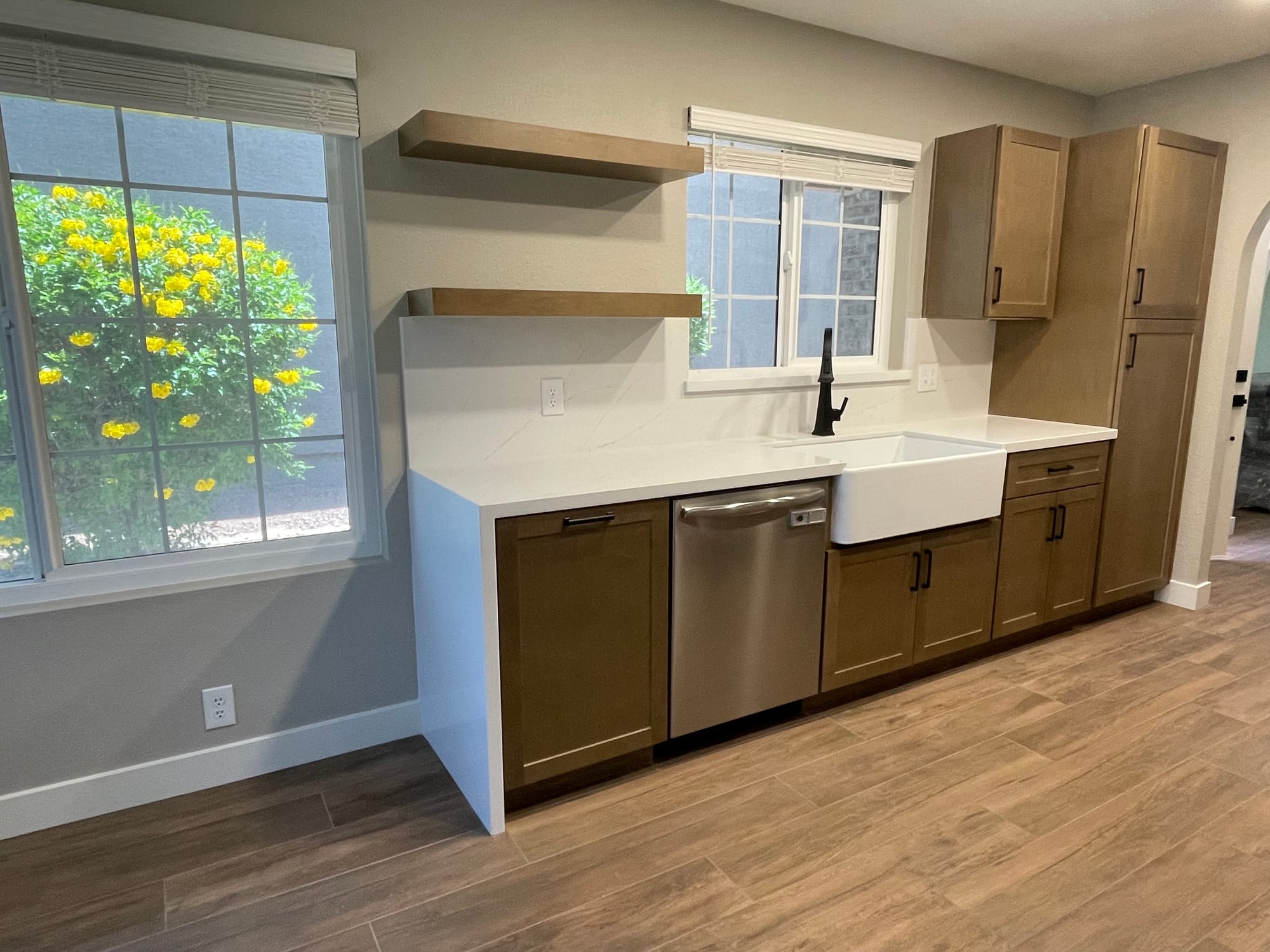 Chandler farmhouse kitchen after — warm maple shaker cabinets and farmhouse sink