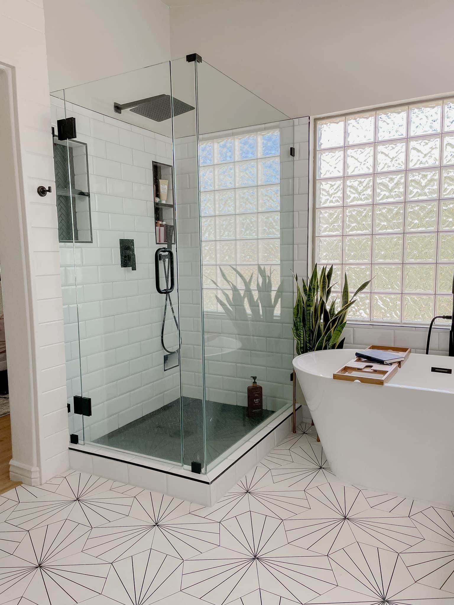 Gilbert master bathroom — frameless walk-in shower in white subway tile with herringbone niche accent and freestanding soaking tub set beside the preserved glass-block window
