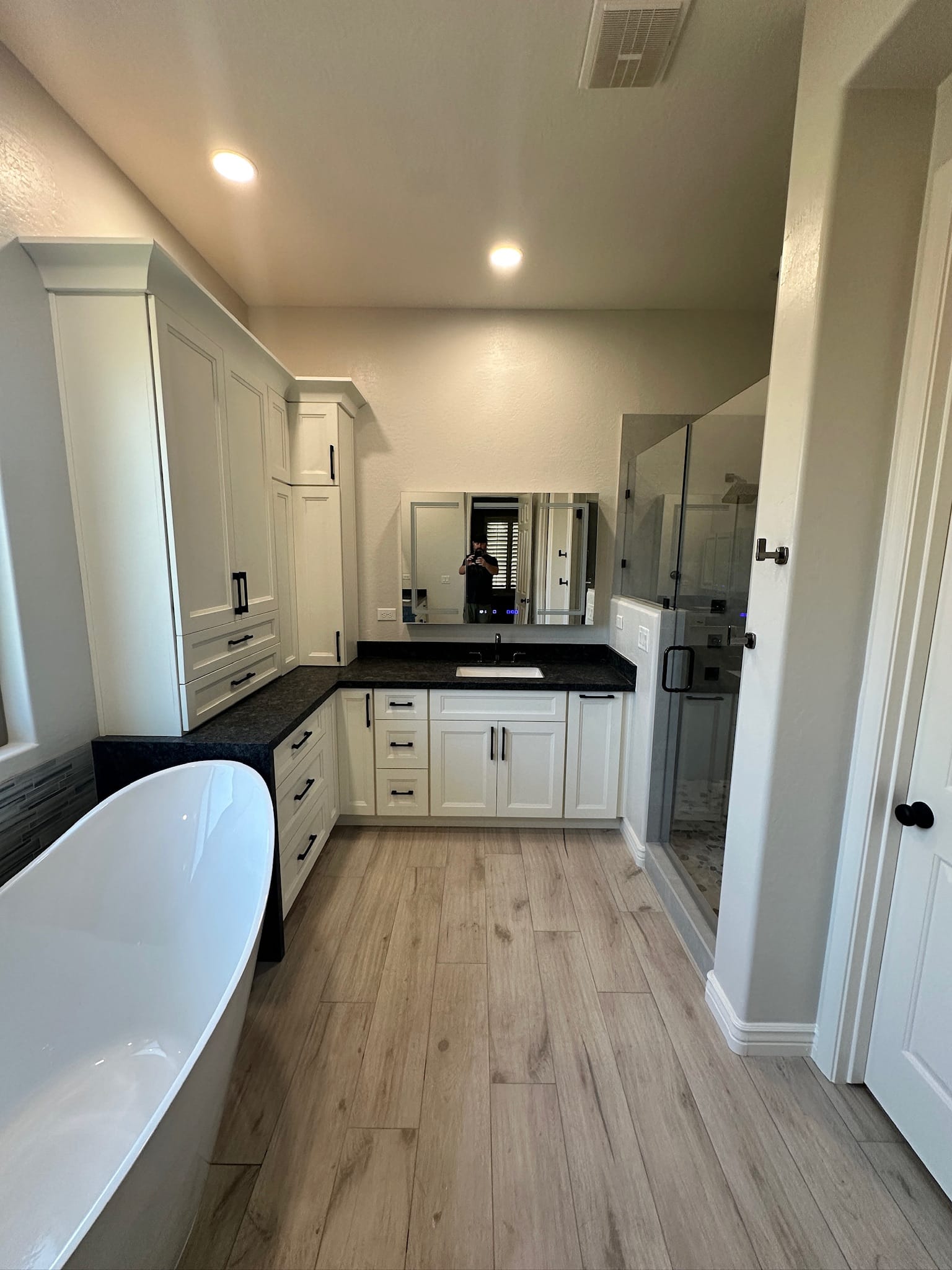 Gilbert bathroom — wide view showing the freestanding slipper tub, white Sollid vanity, walk-in shower, and new flat vaulted ceiling