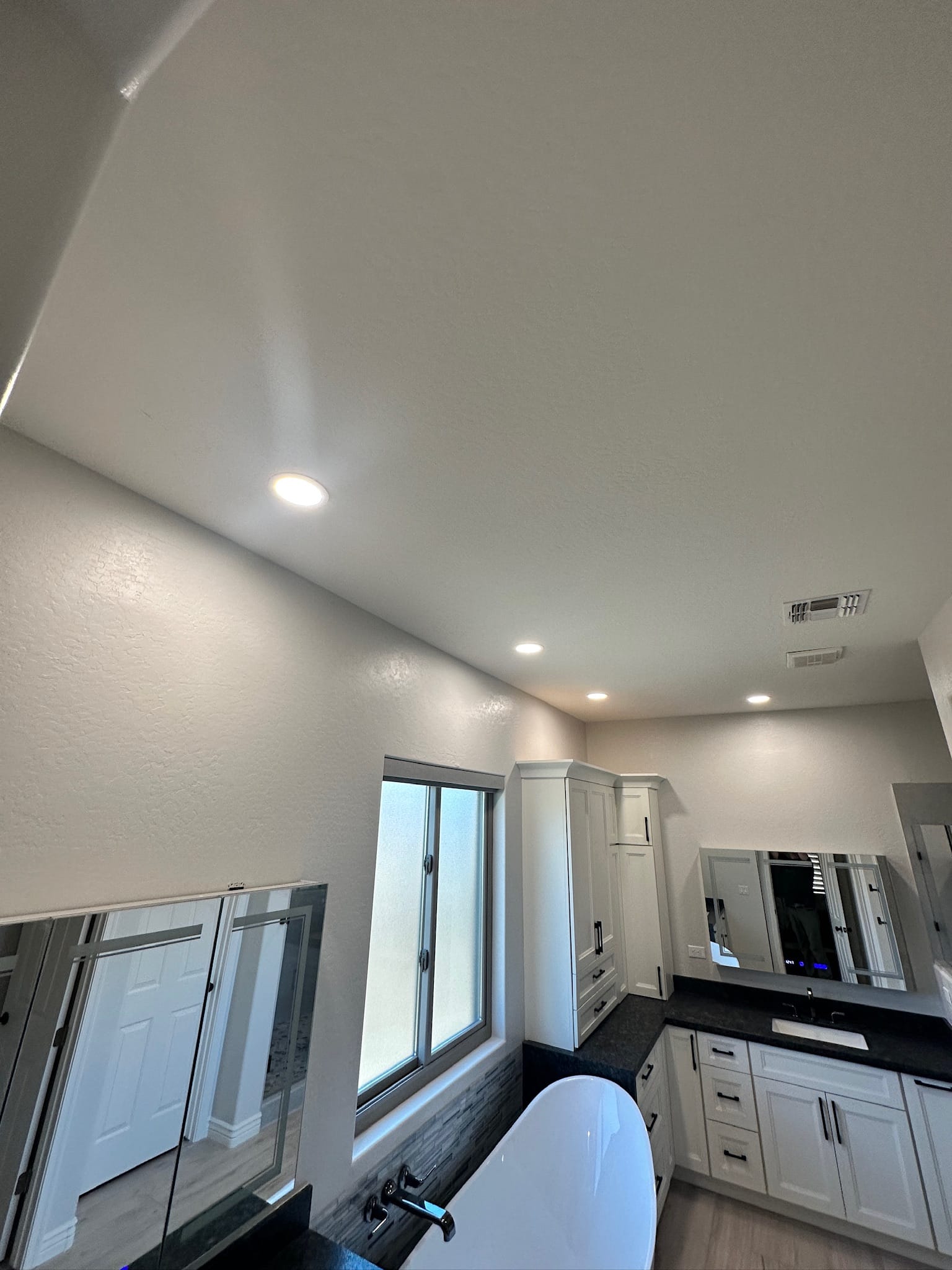 Gilbert bathroom — new flat vaulted ceiling with recessed LED lights after the original dropped soffit was removed