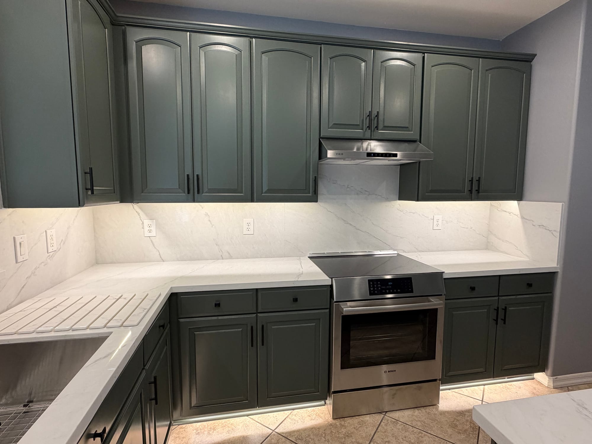 Gilbert kitchen — new Bosch range and hood centered on the sage cabinet wall with Della Terra quartz backsplash