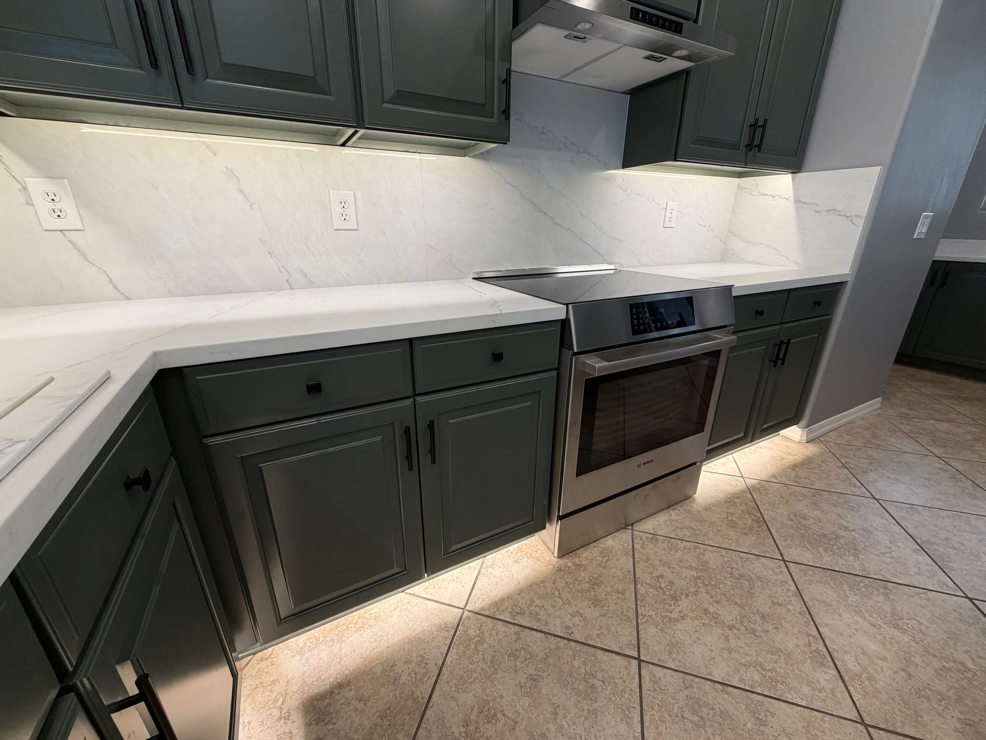 Gilbert kitchen — close-up of the new range and quartz backsplash transition under the sage upper cabinets