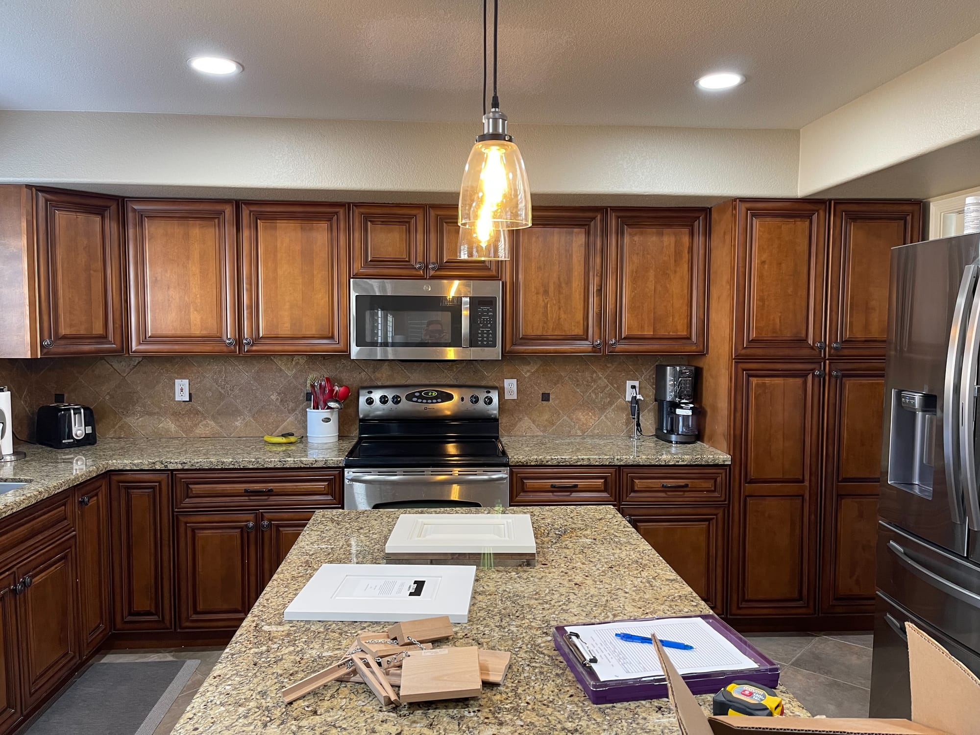 Gilbert kitchen before remodel — dark cherry raised-panel cabinets and travertine backsplash