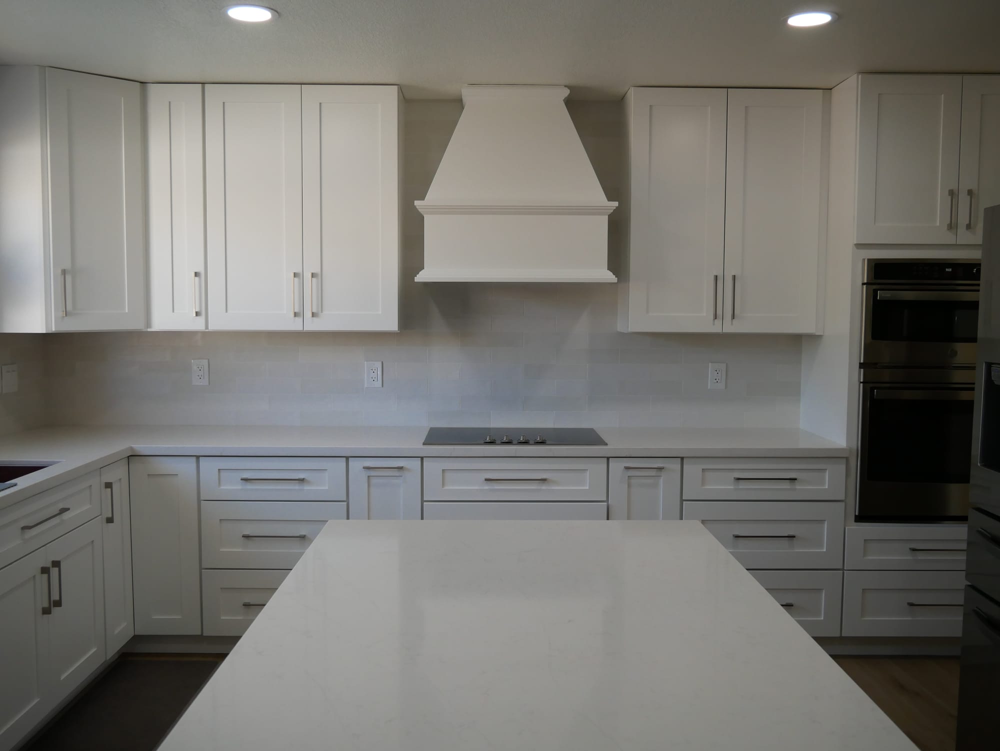 Gilbert kitchen after remodel — white shaker cabinets and custom white wood range hood