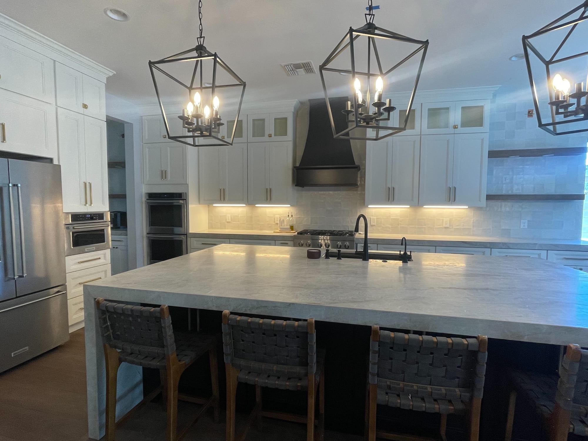 Mesa fire restoration — custom black wood range hood over 6-burner KitchenAid range