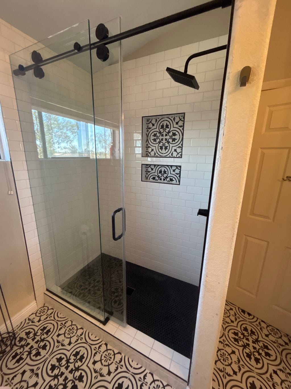 Scottsdale bathroom — vertical view of the subway tile walk-in shower showing the patterned cement-tile niches, matte black hardware, and hexagon black mosaic shower floor